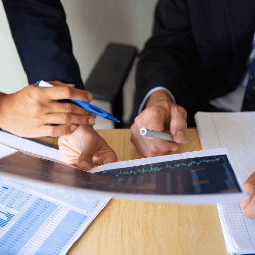 Duas mãos de homens brancos segurando relatórios de fiscalização de produtos controlados